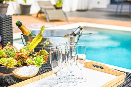 - une table avec des verres à vin et un seau de bouteilles de vin dans l'établissement La Luminy - Villa moderne avec piscine et parking, à Marseille