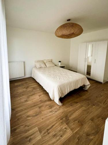 une chambre avec un lit et un parquet dans l'établissement Appartement Moderne 3 Chambres 62 m2 - Saint-Brieuc, à Saint-Brieuc