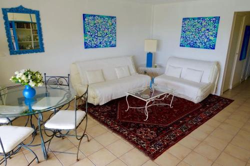 un salon avec un canapé blanc et une table en verre dans l'établissement MAGNIFICENT SEAFRONT Studio, à Mandelieu-la-Napoule