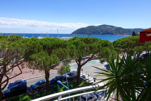 - une vue sur une plage avec des voitures garées dans un parking dans l'établissement MAGNIFICENT SEAFRONT Studio, à Mandelieu-la-Napoule