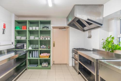 a kitchen with green shelves and a stove at Otter Hostel Connemara in Leenaun