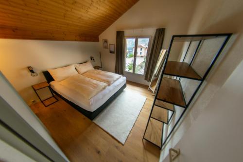 a bedroom with a bed and a window and a mirror at Surfers Lodge with Beach, near Interlaken in Därligen