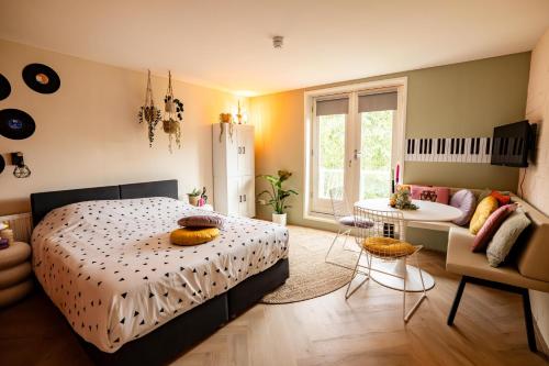 a bedroom with a bed and a living room at Ouder-kind B&B Droomzacht - Natuurkamer in Epe