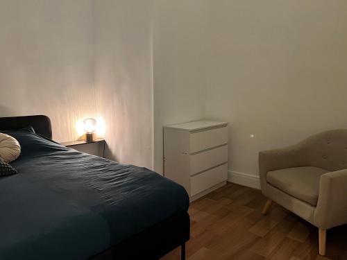 un dormitorio con una cama y una silla en Vert Gallant - Ultra Central - Parking public - Lumineux, en Arras