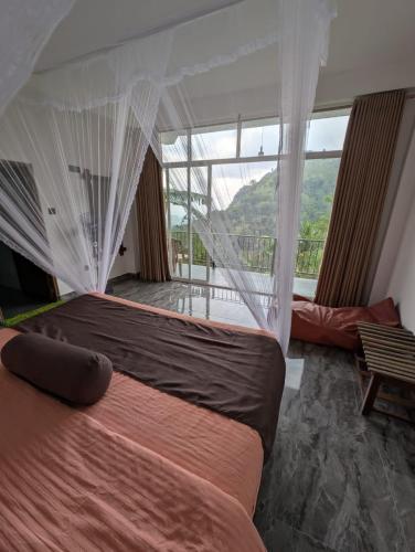 a bedroom with a bed and a large window at Chamodya Home Stay in Ella