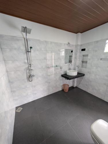 a bathroom with a sink and a shower and a toilet at Chamodya Home Stay in Ella