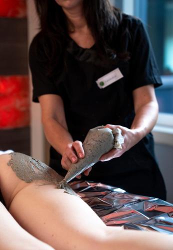 a woman cutting a persons leg with a pair of scissors at Bes Hotel Terme a Palazzago in Palazzago