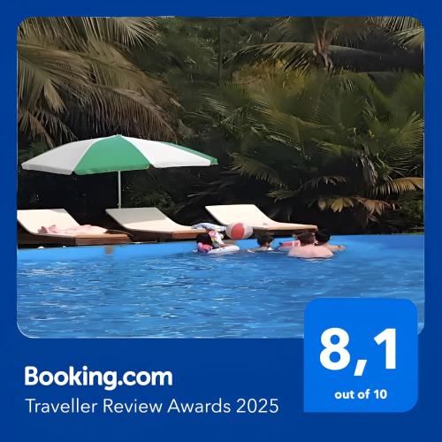 a pool with two lounge chairs and an umbrella at Hotel Nautile in Sainte Marie