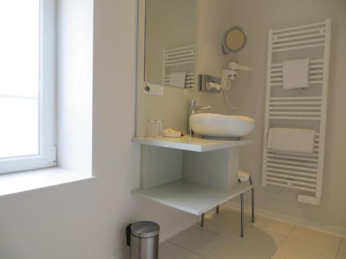 a white bathroom with a sink and a mirror at Auberge Bressane de Buellas in Buellas