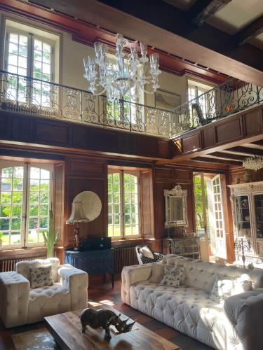 - un salon avec des canapés blancs et un lustre dans l'établissement LA MEFFRAIS 1741 Manoir d'hôtes aux portes de Dinan, à Dinan