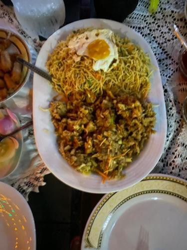 a plate of food with an egg on a table at Nature Paradise Guesthouse in Waikkal