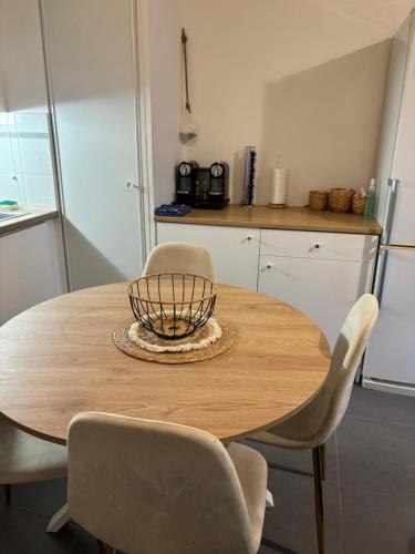 - une table en bois avec des chaises et un bol sur le dessus dans l'établissement Appart cosy, à La Seyne-sur-Mer