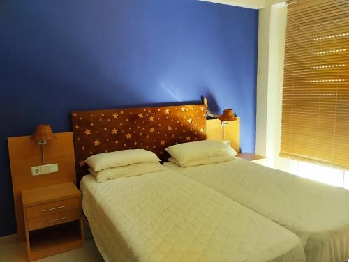 a bedroom with a large bed with a blue wall at Apartamento Vera-playa in Los Amarguillos