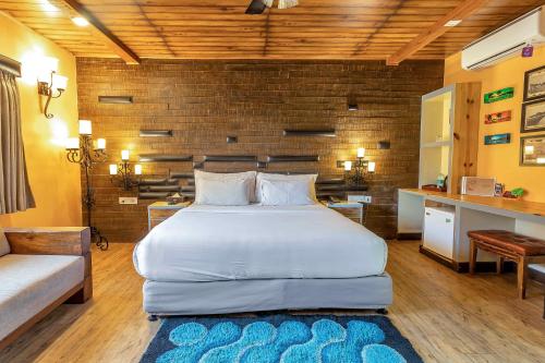 a bedroom with a large white bed and a desk at The Baga Beach Resort in Baga
