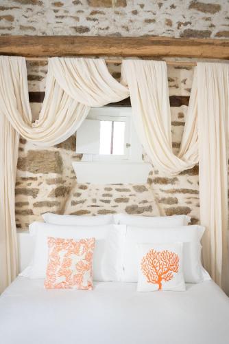 - une chambre avec un lit blanc et des rideaux blancs dans l'établissement LA MEFFRAIS 1741 Manoir d'hôtes aux portes de Dinan, à Dinan