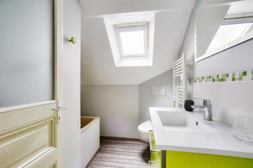 une salle de bain avec un lavabo et des toilettes et une fenêtre dans l'établissement Ty Glaz - Jardin - Véranda - 800 m de la plage, à Dinard