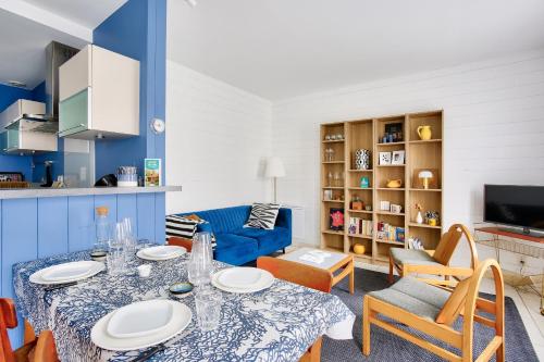 un salon avec une table et un canapé dans l'établissement Ty Glaz - Jardin - Véranda - 800 m de la plage, à Dinard