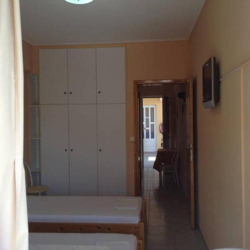 a bedroom with a bed and a large white cabinet at Despoina Apartments in Edipsos