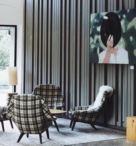 a living room with two chairs and a painting on the wall at Falkensteiner Hotel Schladming Superior in Schladming