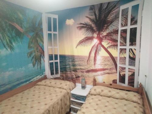 a bedroom with two beds and a palm tree mural at Camino Bed and Breakfast Corme in Corme-Puerto