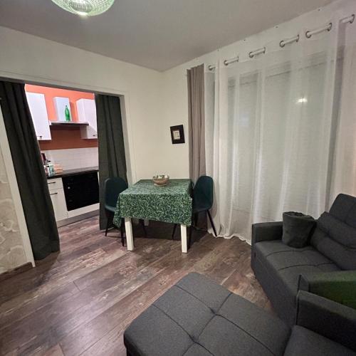 un salon avec une table et un canapé dans l'établissement Studio au calme avec stationnement, à Bagnoles-de-l'Orne