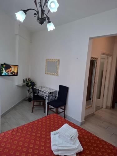 a room with a table and a bed with a red carpet at Le Maschere in Mestre
