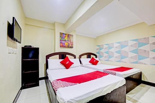 a bedroom with two beds with red pillows at OYO 894 Cosmo Hotel P Campa Manila in Manila