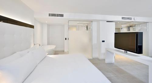 a white room with a tv and a bed at INNSiDE by Meliá Palma Bosque in Palma de Mallorca