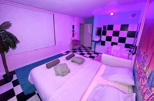 Ένα ή περισσότερα κρεβάτια σε δωμάτιο στο Capsule Miami Vice - Jacuzzi - Billard - Ecran cinéma & Netflix - Ping-Pong - Nintendo & Jeux-