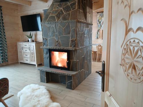 a living room with a stone fireplace in a house at Tatra West Farm in Dzianisz