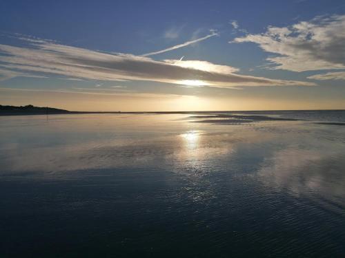 a view of the ocean with the sun reflecting on the water at The Nest on the Water in Chichester