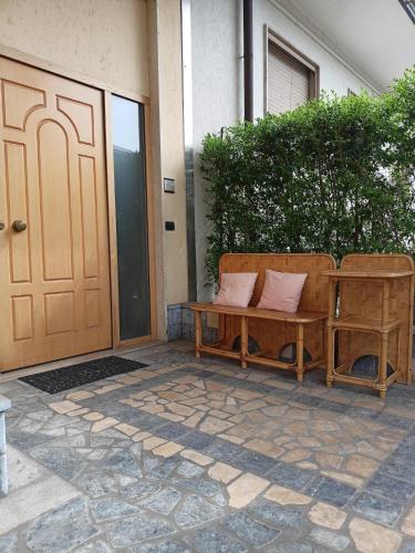 a wooden bench sitting next to a door at Casa Vanessa Appartamento in Villa - Humanitas in Pieve Emanuele