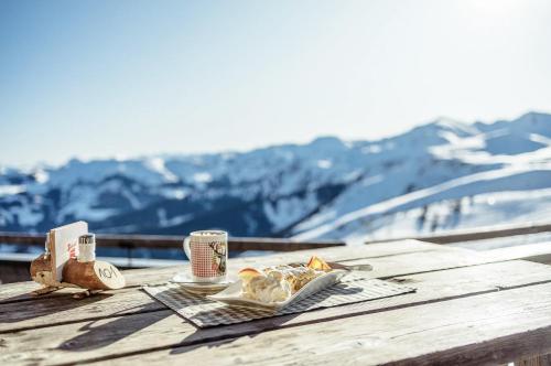 a table with a plate of food and two cups of coffee at PENTHOUSE N`4 - Stylish Apartment with Rooftop Whirlpool Access in Tyrol, presented by AlpenLuxus in Kramsach