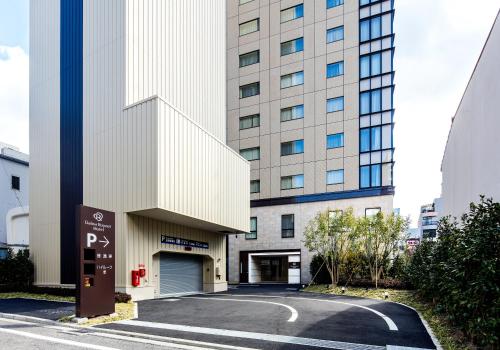 松山的住宿－松山大和魯內酒店，前面有停车标志的建筑
