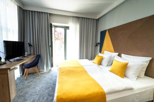 a hotel room with a large bed and a desk at Villa Ozone in Sopot
