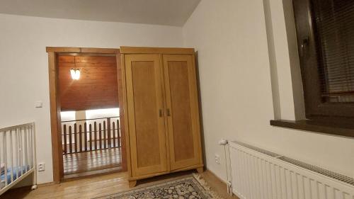 a wooden cabinet in a room with a balcony at The House Next to the Forest - LAKMAT in Nové Hamry