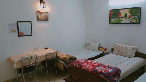 una habitación con una cama, una mesa y sillas en SOLAN HOSTELz, en Solan