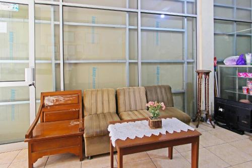 a living room with a couch and a coffee table at Hotel O Meilias in Cilacap