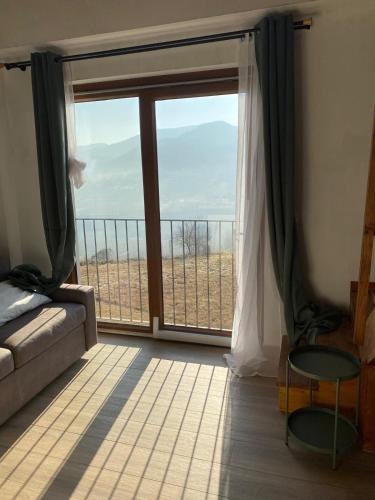 a living room with a large window with a view at Agriturismo Casa del Principe in Torre Bormida