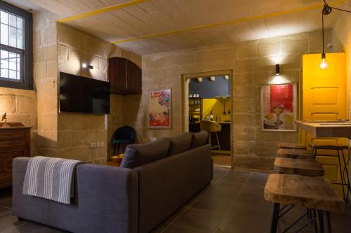 una sala de estar con un sofá y una mesa en Escape to a Unique 2 Bed Apt in Heart of Valletta, en La Valeta