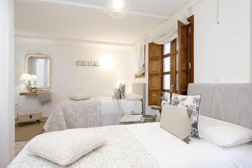 Postel nebo postele na pokoji v ubytování Apartamentos LA TONÁ Puerta Elvira centro ciudad