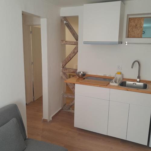 a white kitchen with a sink and a counter at Chiado Carmo Sunny Lodge in Lisbon