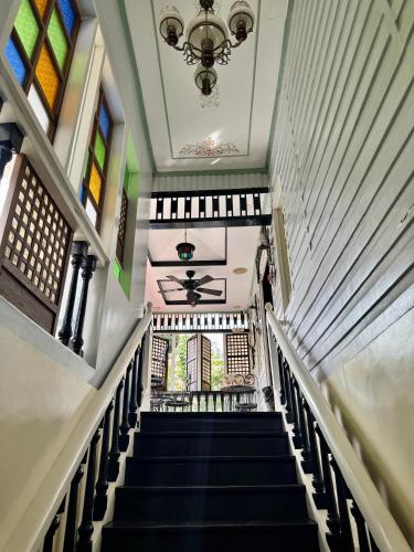 a staircase in a building with a chandelier at Park Avenue Boutique Hotel Manila in Manila