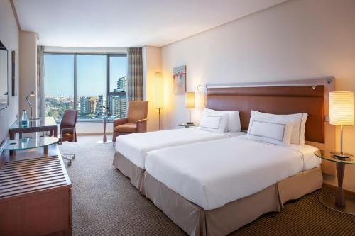 a hotel room with a large bed and a large window at Melia Valencia in Valencia