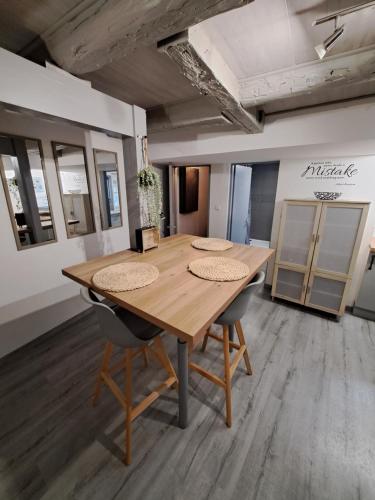 a wooden table and chairs in a room at Magnifique F2 du bien être in Besançon
