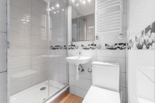 a white bathroom with a toilet and a sink at CZTERY KĄTY - Przyjazne zwierzętom, Bezpłatne rowery, Kąty Rybackie in Kąty Rybackie