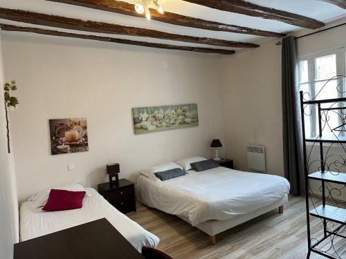 une chambre avec deux lits et une table dans l'établissement Maison de ville pour groupe, très proche du château de Villandry, à Villandry