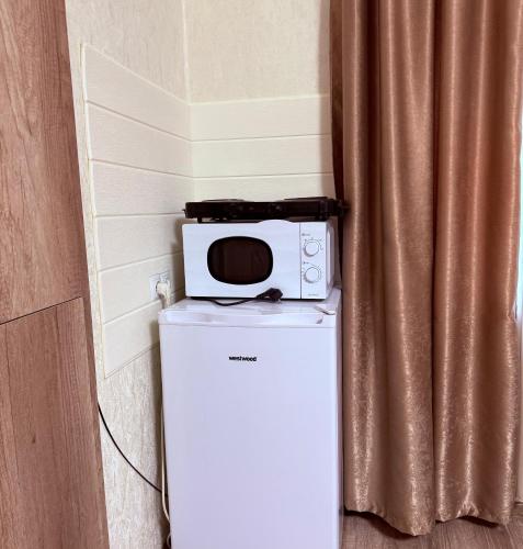 un forno a microonde sopra un frigorifero accanto a una tenda di Avlabar Home a Tbilisi City