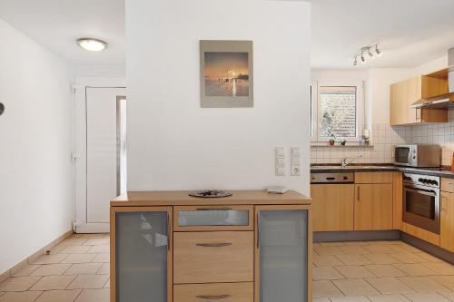 a kitchen with white walls and wooden cabinets at Obstbau Koch in Bodman-Ludwigshafen