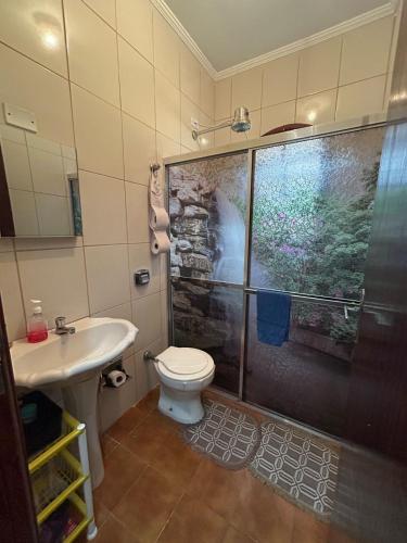 ein Badezimmer mit Dusche, Toilette und Waschbecken in der Unterkunft Casa Praia Grande pé na areia in Praia Grande